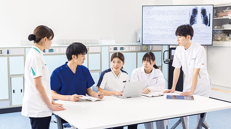 テーブルで男女5人のチームで相談している様子