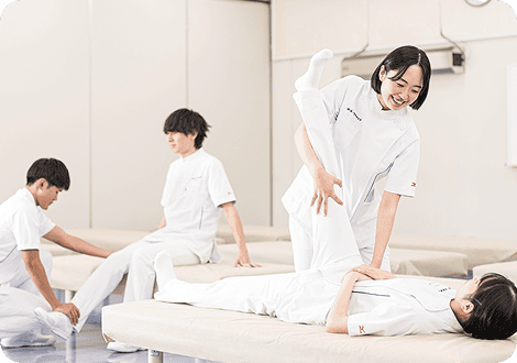 学生同士で脚の療法を行う男子学生と女子学生