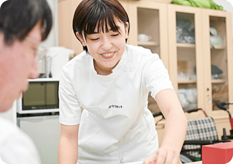 笑顔で男性に療法を行う女子学生