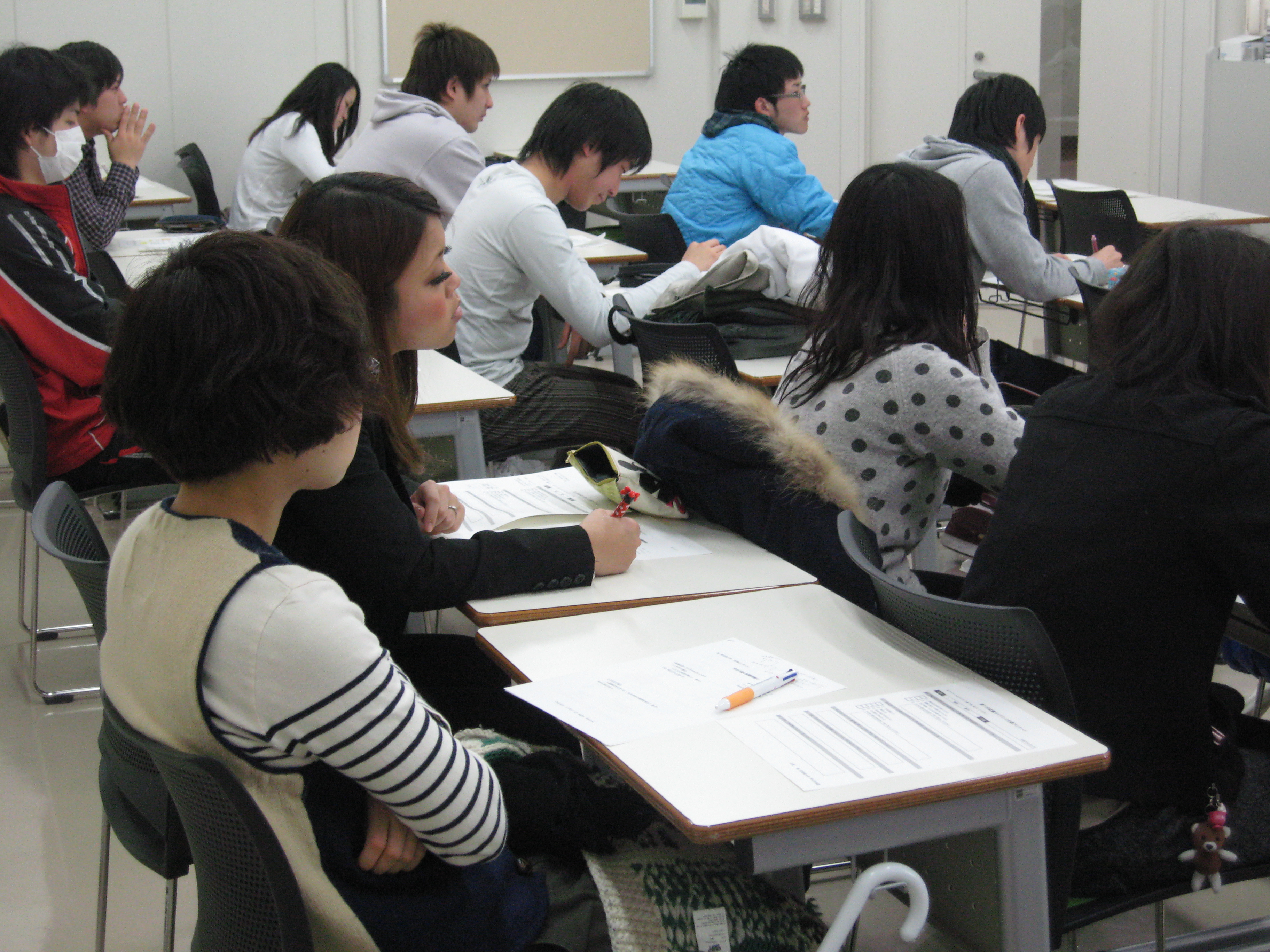 熱心にメモをとる学生  